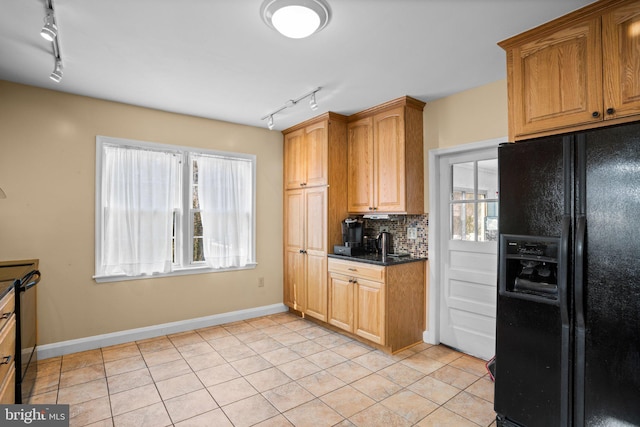 kitchen with light tile patterned flooring, dishwasher, backsplash, dark stone counters, and black refrigerator with ice dispenser