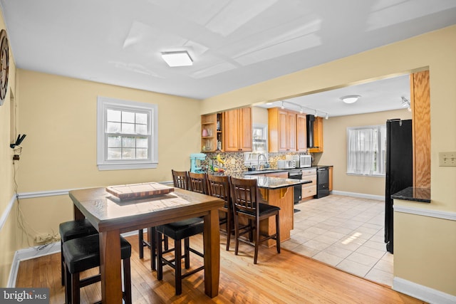 dining space featuring light tile patterned flooring, plenty of natural light, and sink