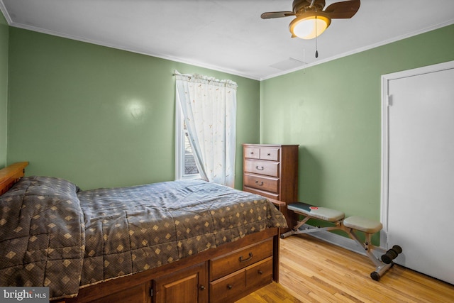 bedroom featuring ornamental molding, ceiling fan, and light wood-type flooring