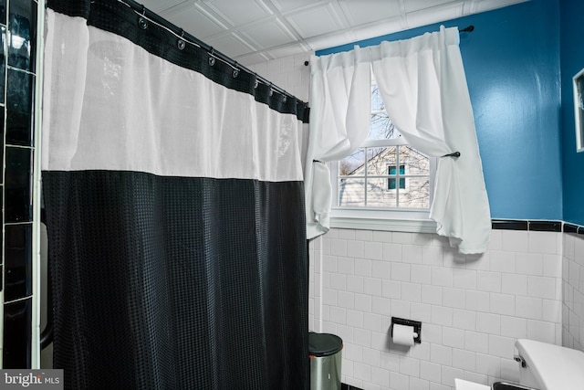 bathroom featuring tile walls and curtained shower