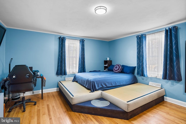 bedroom featuring ornamental molding and light wood-type flooring