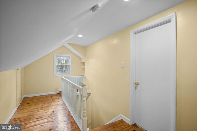 hallway featuring vaulted ceiling and light wood-type flooring