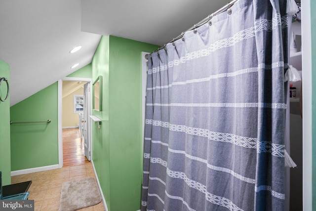 bathroom featuring tile patterned flooring and vaulted ceiling