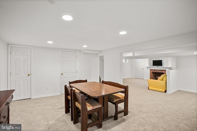 carpeted dining room with a fireplace