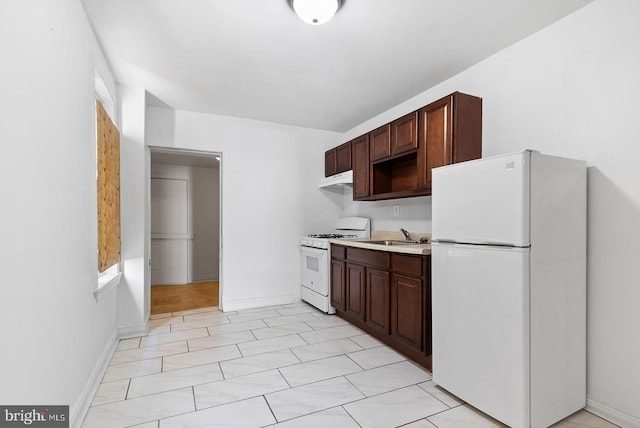 kitchen featuring dark brown cabinets, sink, and white appliances