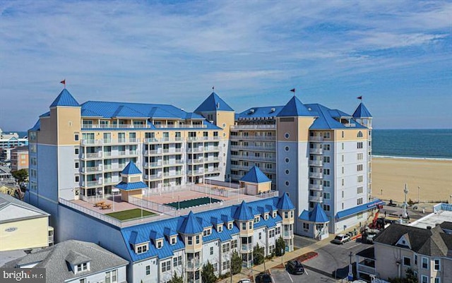 view of building exterior featuring a water view and a beach view