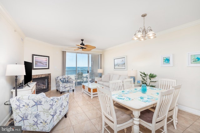 dining area featuring ornamental molding, light tile patterned floors, and a high end fireplace