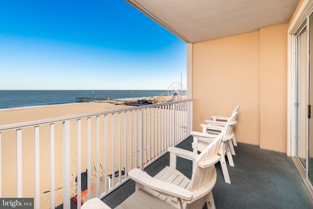 balcony featuring a water view and a view of the beach