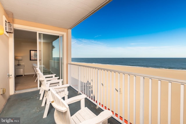 balcony with a water view and a view of the beach