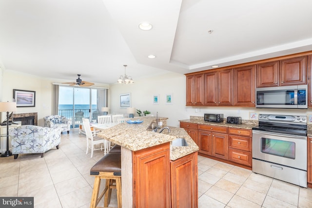 kitchen with decorative light fixtures, sink, a kitchen bar, a kitchen island with sink, and stainless steel appliances