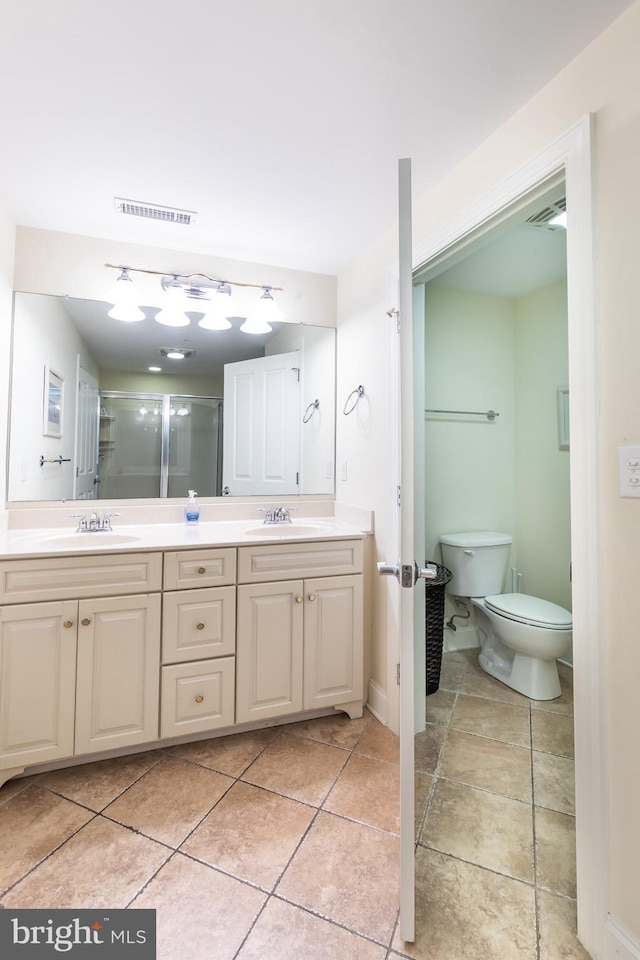 bathroom with toilet, vanity, tile patterned floors, and walk in shower