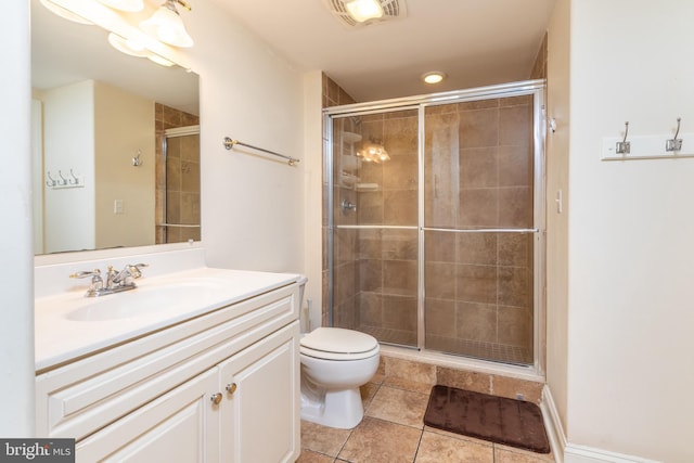 bathroom featuring vanity, toilet, tile patterned floors, and a shower with shower door