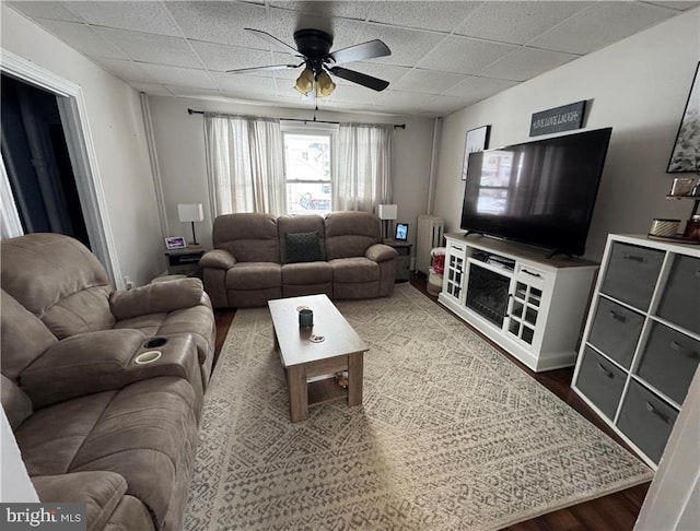 living room with wood-type flooring, a drop ceiling, and ceiling fan