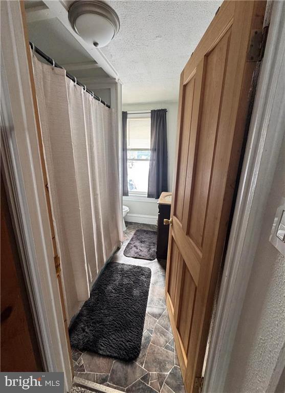 bathroom featuring a textured ceiling and toilet