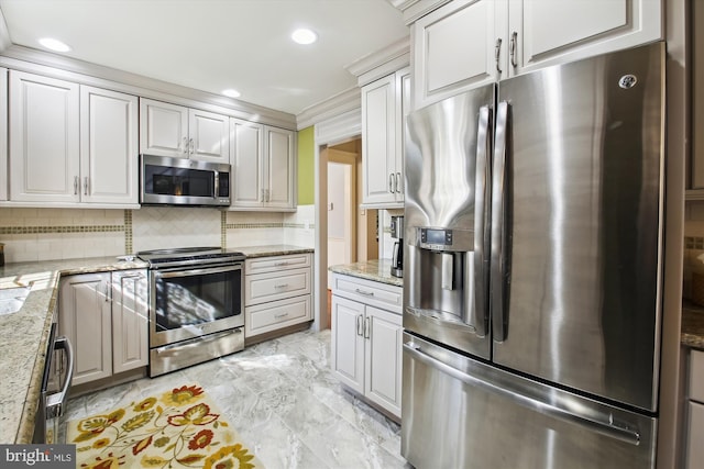 kitchen with light stone counters, white cabinetry, stainless steel appliances, and decorative backsplash