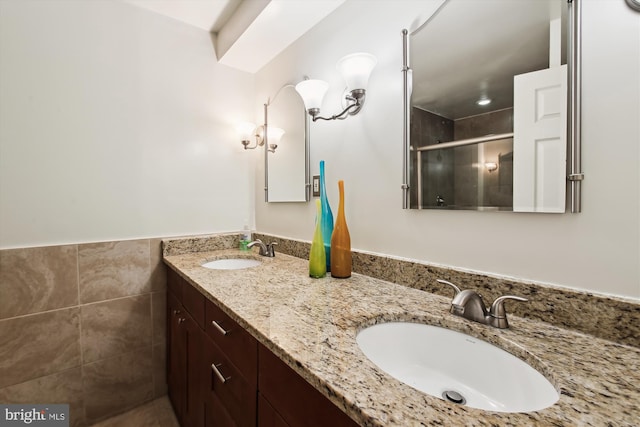 bathroom featuring vanity, tile walls, and a shower with shower door