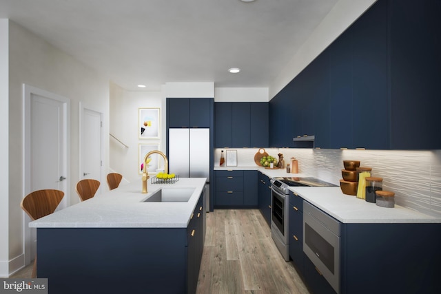 kitchen with sink, stainless steel appliances, an island with sink, and a breakfast bar