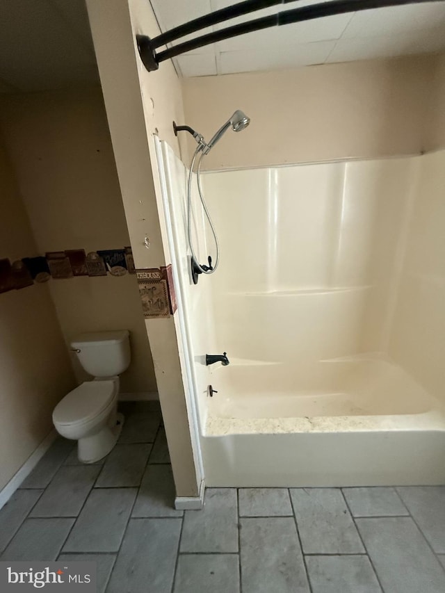 bathroom featuring tile patterned flooring, shower / bathing tub combination, and toilet