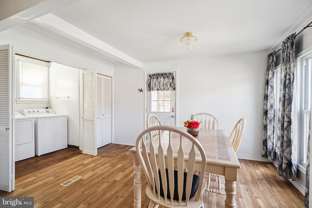 dining area with washer and clothes dryer and light wood-type flooring