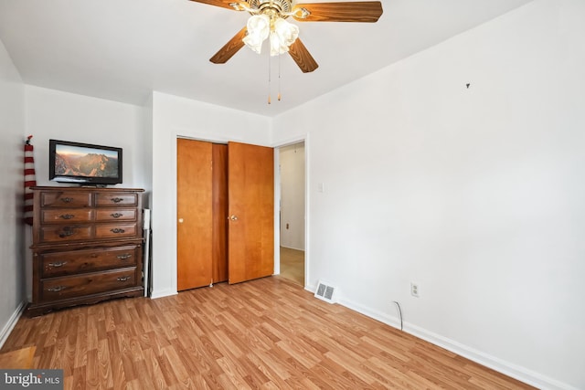 unfurnished bedroom with ceiling fan, a closet, and light hardwood / wood-style flooring