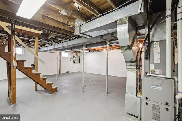 basement featuring electric panel and heating unit