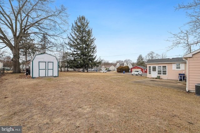 view of yard featuring a shed and central AC unit