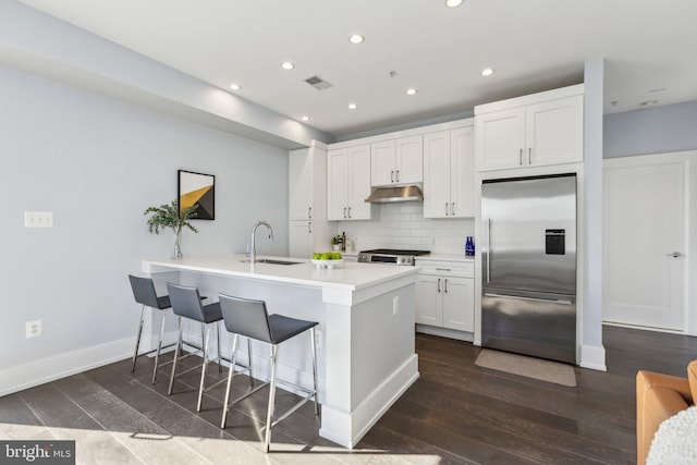 kitchen featuring sink, white cabinets, backsplash, built in refrigerator, and kitchen peninsula