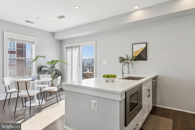 kitchen featuring sink, dark wood-type flooring, kitchen peninsula, and appliances with stainless steel finishes