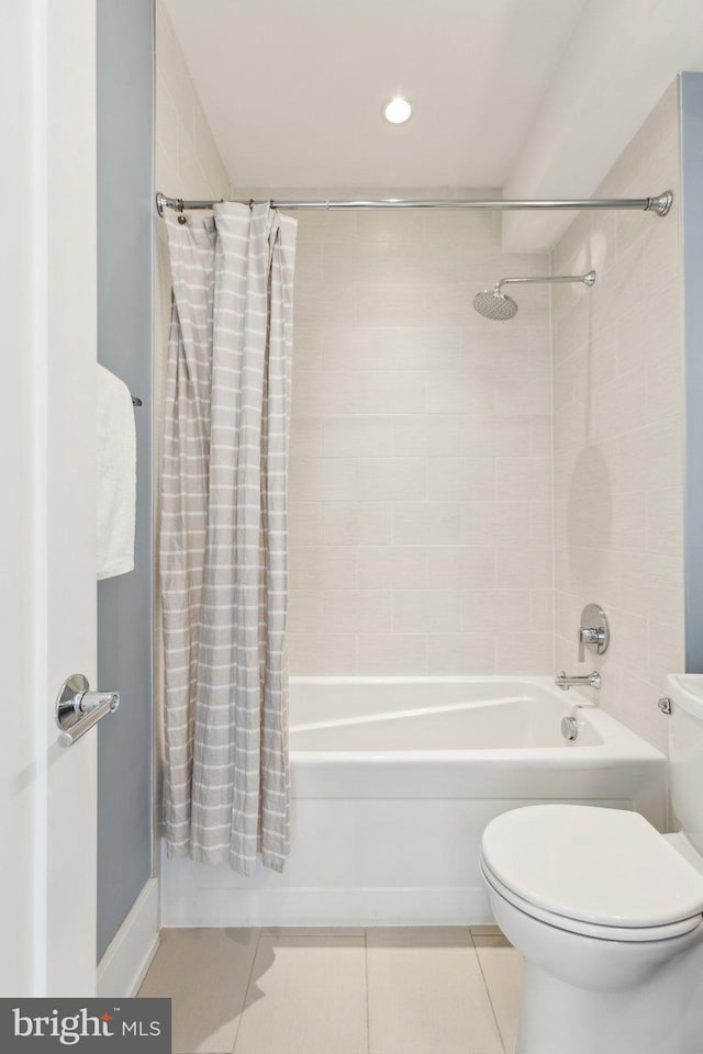 bathroom with shower / tub combo with curtain, tile patterned floors, and toilet