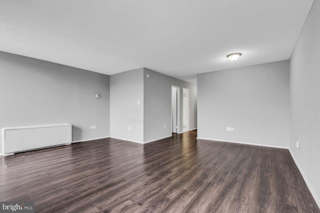 empty room with dark hardwood / wood-style flooring