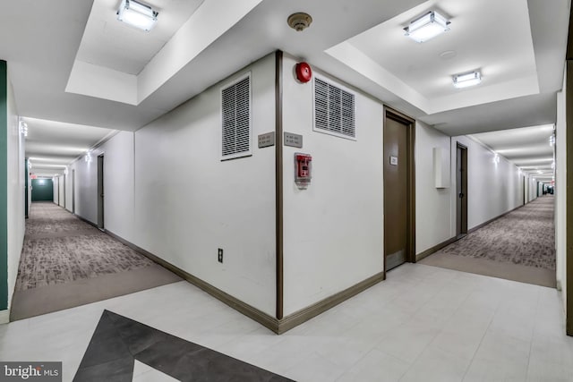 hall featuring a raised ceiling