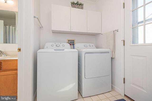 laundry area featuring cabinets, washing machine and clothes dryer, and sink