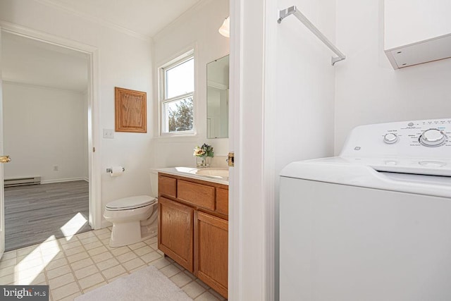 bathroom with toilet, a baseboard radiator, vanity, ornamental molding, and washer / clothes dryer