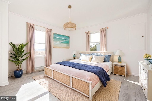 bedroom featuring ornamental molding and light wood-type flooring