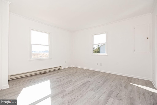 empty room with crown molding, a wealth of natural light, light hardwood / wood-style flooring, and a baseboard heating unit