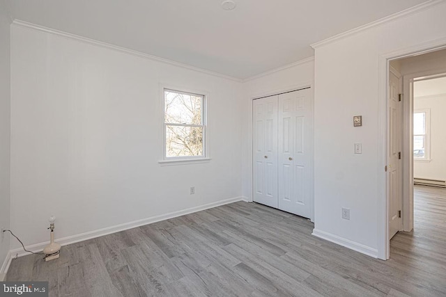 unfurnished bedroom with multiple windows, crown molding, and light hardwood / wood-style flooring