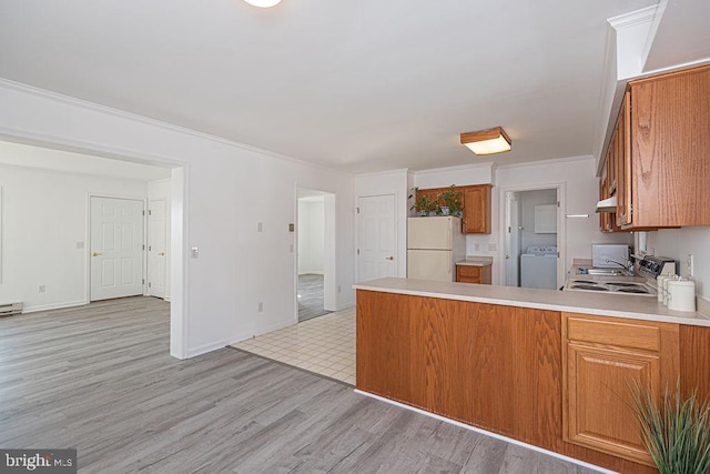 kitchen with white refrigerator, washer / clothes dryer, crown molding, and light wood-type flooring