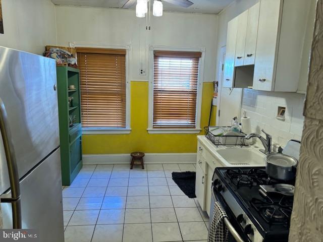 kitchen featuring tasteful backsplash, light countertops, appliances with stainless steel finishes, white cabinetry, and a sink