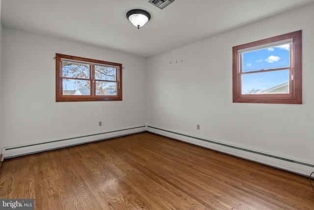 empty room featuring baseboard heating and light wood-type flooring