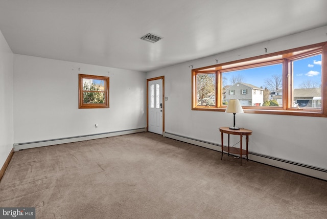 carpeted spare room featuring a baseboard radiator and plenty of natural light