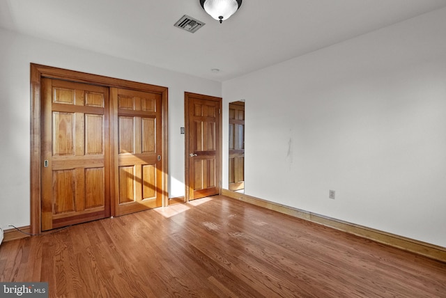 unfurnished bedroom featuring light hardwood / wood-style floors and a closet