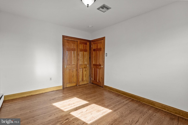 unfurnished bedroom featuring a closet and light wood-type flooring