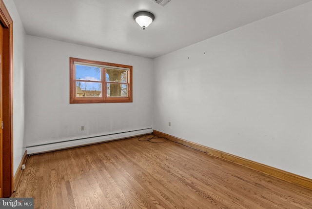 unfurnished room featuring light wood-type flooring and baseboard heating