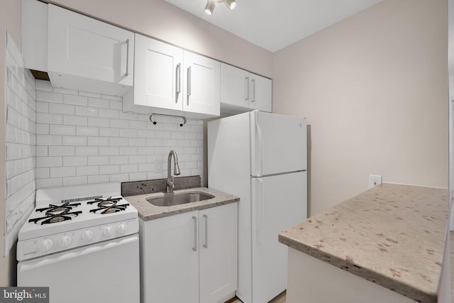 kitchen featuring sink, tasteful backsplash, white appliances, light stone countertops, and white cabinets