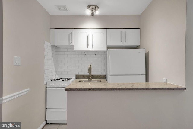 kitchen featuring sink, white appliances, white cabinetry, tasteful backsplash, and light stone countertops