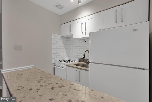 kitchen featuring white cabinetry, sink, white appliances, and tasteful backsplash