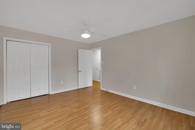 unfurnished bedroom with light hardwood / wood-style flooring, a closet, and ceiling fan