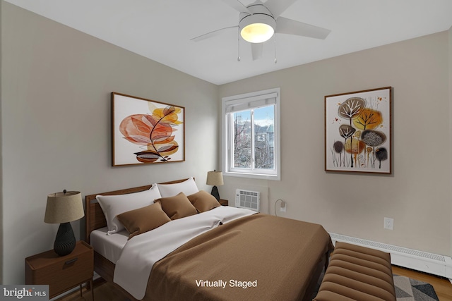 bedroom featuring a wall unit AC, ceiling fan, and baseboard heating