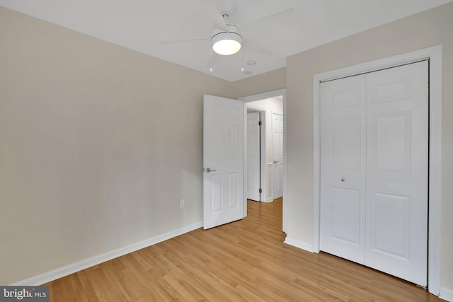 unfurnished bedroom featuring ceiling fan, light wood-type flooring, and a closet