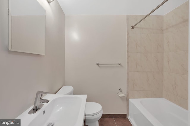 full bathroom with tiled shower / bath, tile patterned floors, toilet, and sink